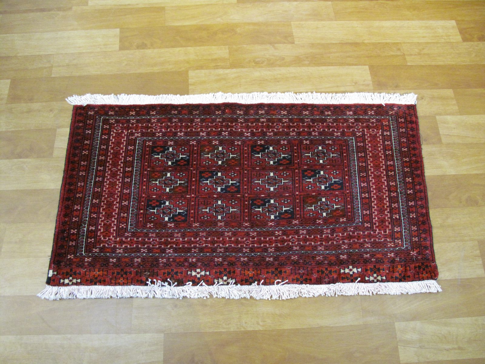 فرش دستباف ترکمن طرح خشتي سایز پشتي رنگ زمینه لاكي رنگ حاشیه لاكي کد ۴۱۳۸۵ سایز ۱٫۰۷ در X 0.56