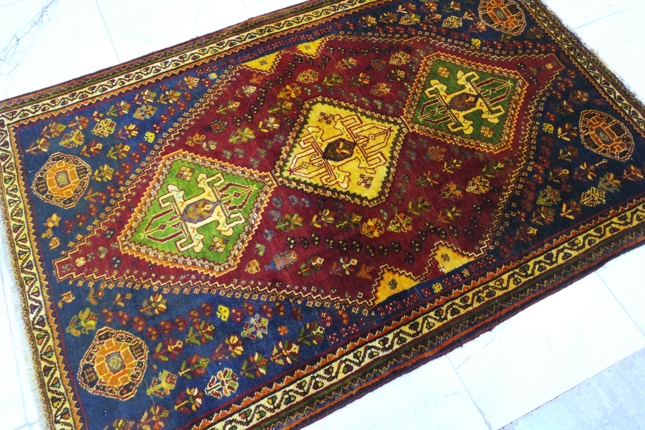 فرش دستباف شيراز ترکباف طرح ۳ ترنج سایز ذرع  و نيم۱٫۶۳×۱٫۰۵ رنگ زمینه لاكي رنگ حاشیه كرم کد ۴۲۲۸۴