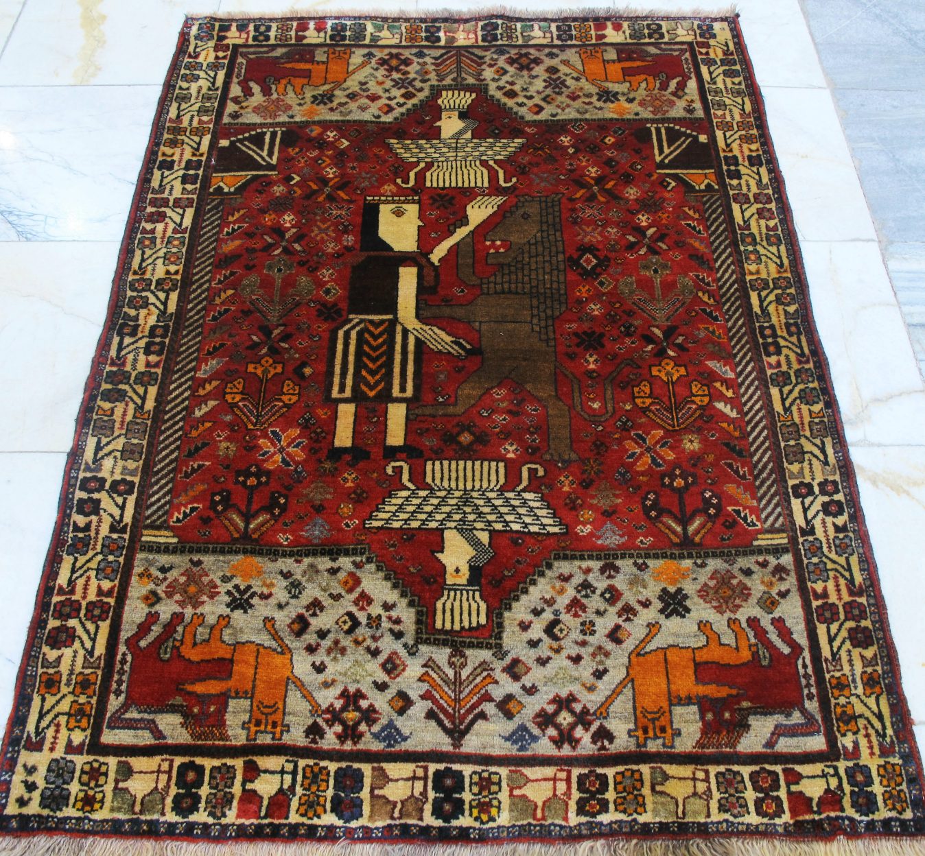 فرش دستباف شيراز ترکباف طرح تخت جمشيد سایز ذرع  و نيم۱٫۵۴×۱٫۰۸ رنگ زمینه لاكي رنگ حاشیه كرم کد ۴۲۲۶۴